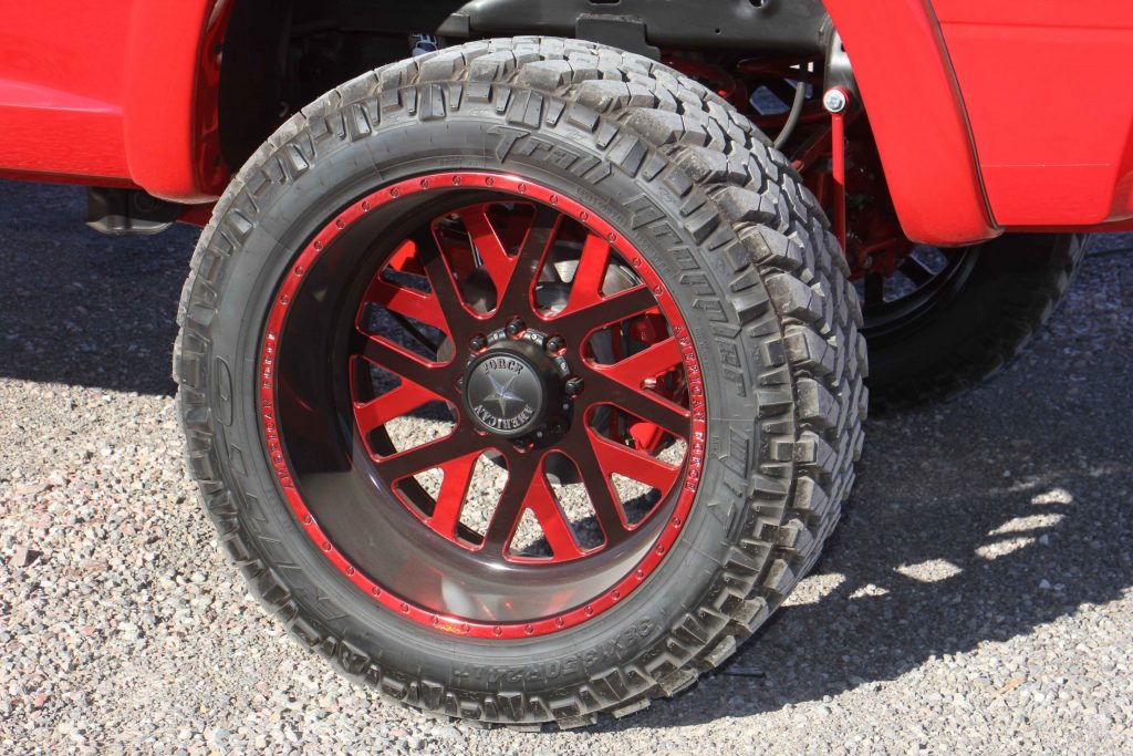 Rolling stock is a set of American Force 24x12 inch Whiskey SF8s with a custom red finish, wrapped in 38-inch tall Nitto Trail Grapplers.