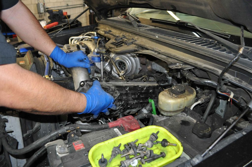 Hector pulled the valve cover bolts using a ¼-inch air ratchet, and removed the valve cover.