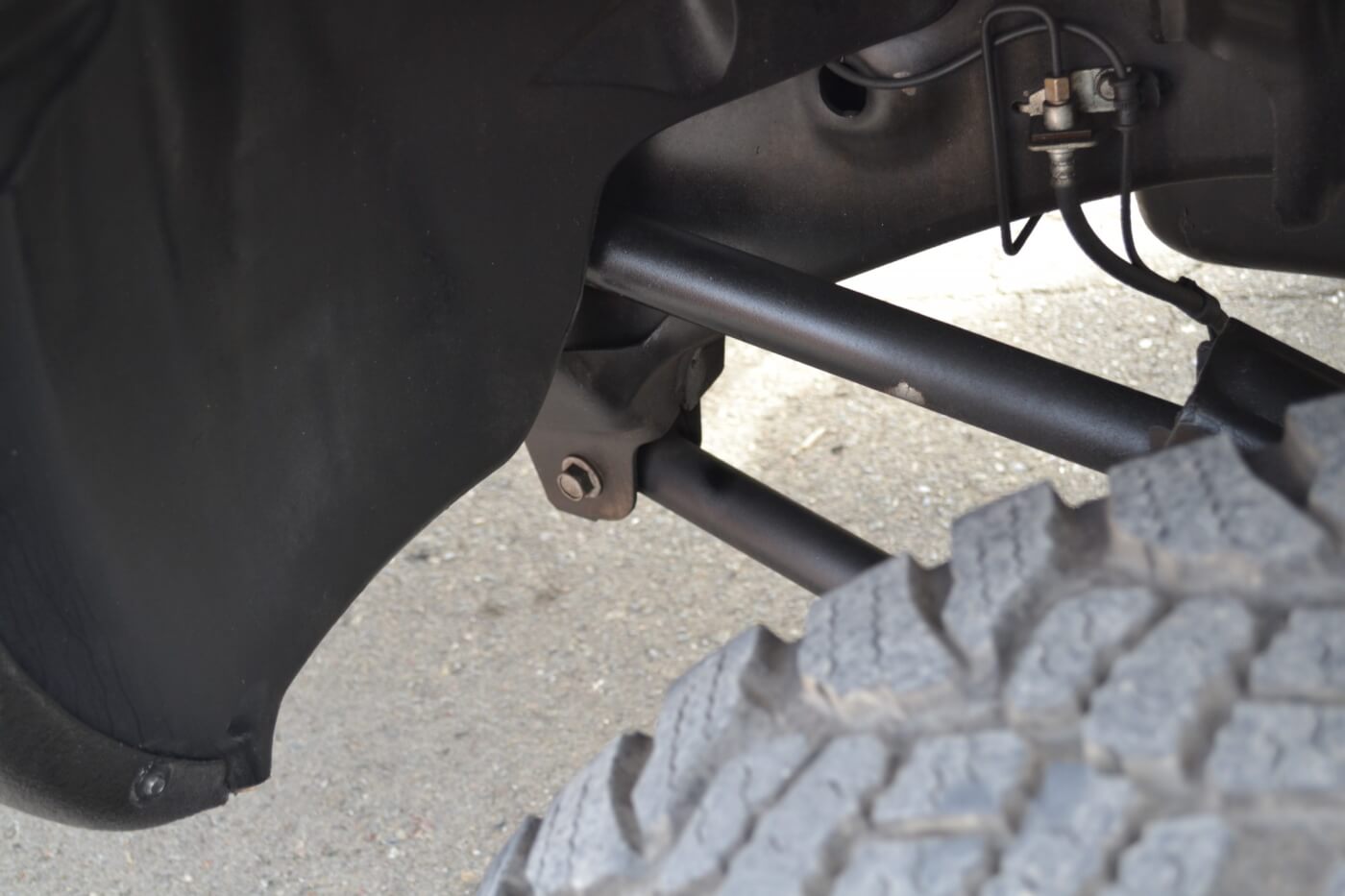 A subtle lift and aftermarket link arms are used to clear the Ram's oversized tires. The arms and 4-inch lift are both products from Top Gun Customs.