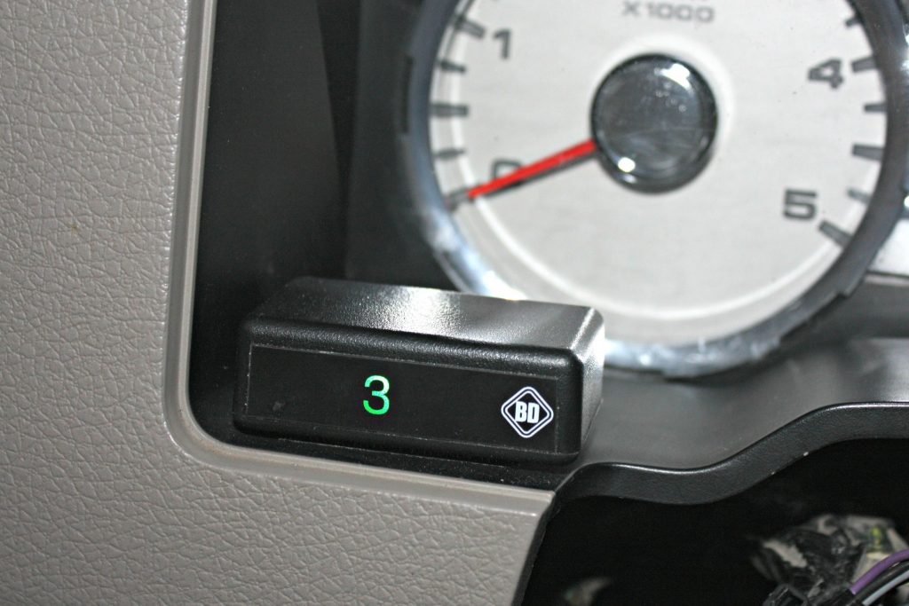 9. The Tapshifter kit includes this handy little display to show drivers which gear has been selected while in the manual shift mode. The module will display gears 1-5 as selected by the button on the shift lever. It can be placed within easy viewing right on the dash panel behind the steering wheel using the included double-sided Velcro tape (no drilling required).