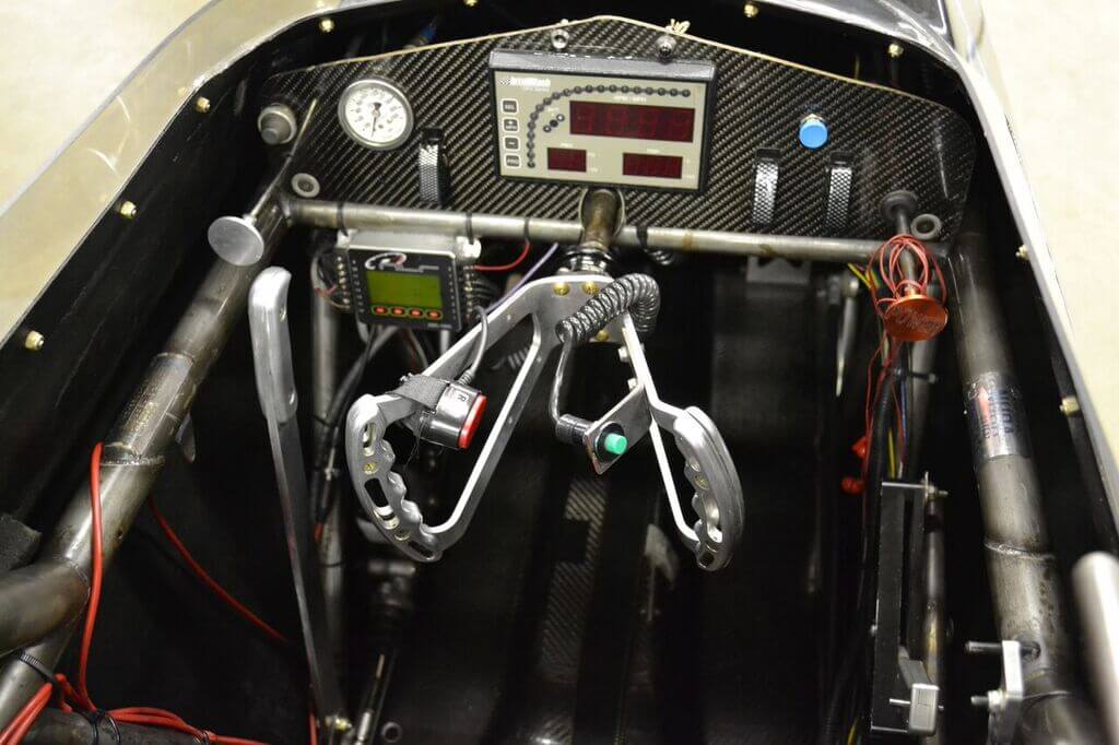 The hot seat that driver Jared Jones sits in for around 6 seconds at a time is all business. A butterfly steering wheel allows for quick inputs, the large lever on the left is a hand brake that is used for staging, and the pedals on the floor are for the clutch and the throttle.