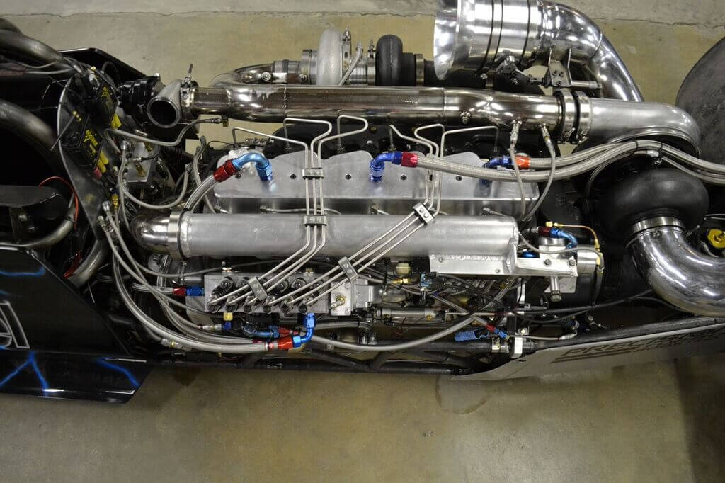 The 2,500hp Cummins in the Scheid dragster is a marvel of modern diesel engineering. It features a Fluidampr and mounting system of Dan's own design, a 6.7L crankshaft, Scheid connecting rods, and Arias 12:1 compression pistons to arrive at 6.4L of displacement. Valve actuation is courtesy of a Scheid roller camshaft, and above the fire-ringed block lies a heavily ported cylinder head from Hamilton Cams, with 225-pound valve springs. The long block is good for a whole season's worth of 6,000rpm passes.