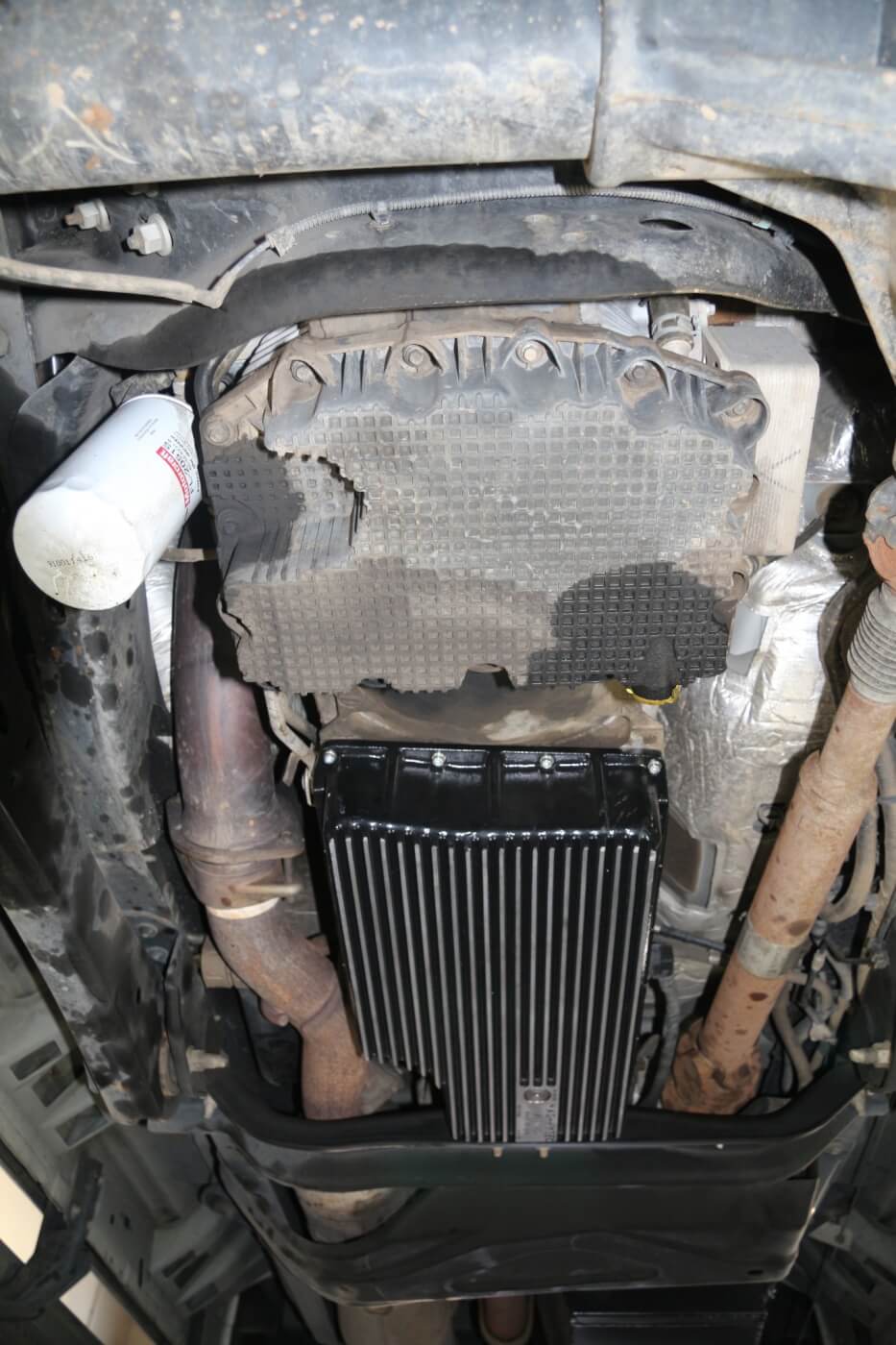 2. In this view, you can see the oil pan drain leak area (right), and a spot from oil dripping off the filter (left). This filter drip is likely from past oil changes, as filter leaking on the 6.7L is usually only reported when the filters are not properly installed.