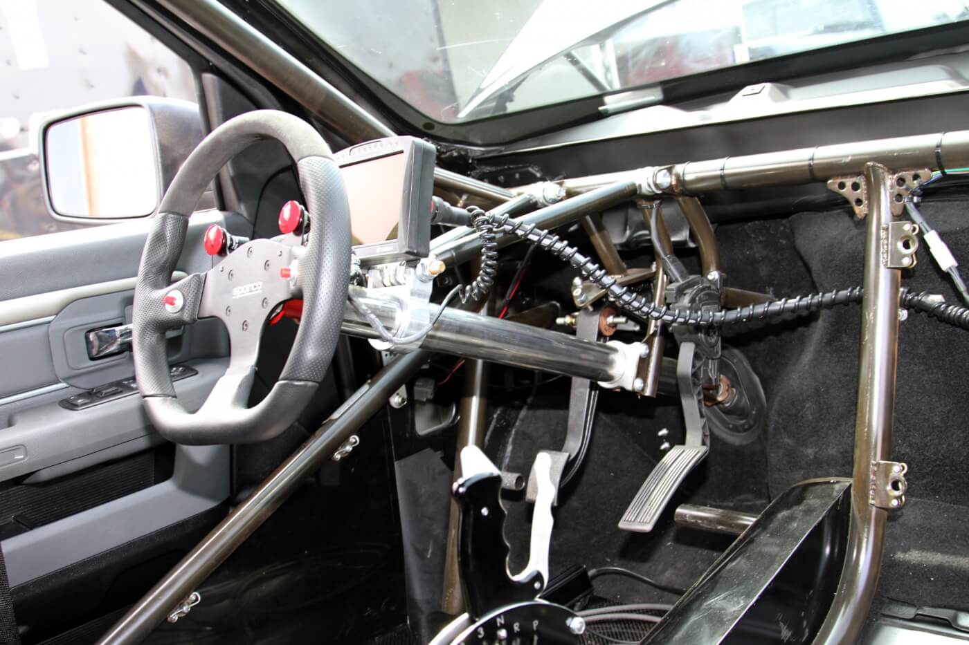 The roll cage provides a solid anchor point for the steering column and pedal assemblies. Milliken has a great view of the engine vitals with the Bosch Motorsport Display mounted in front of the Sparco steering wheel.