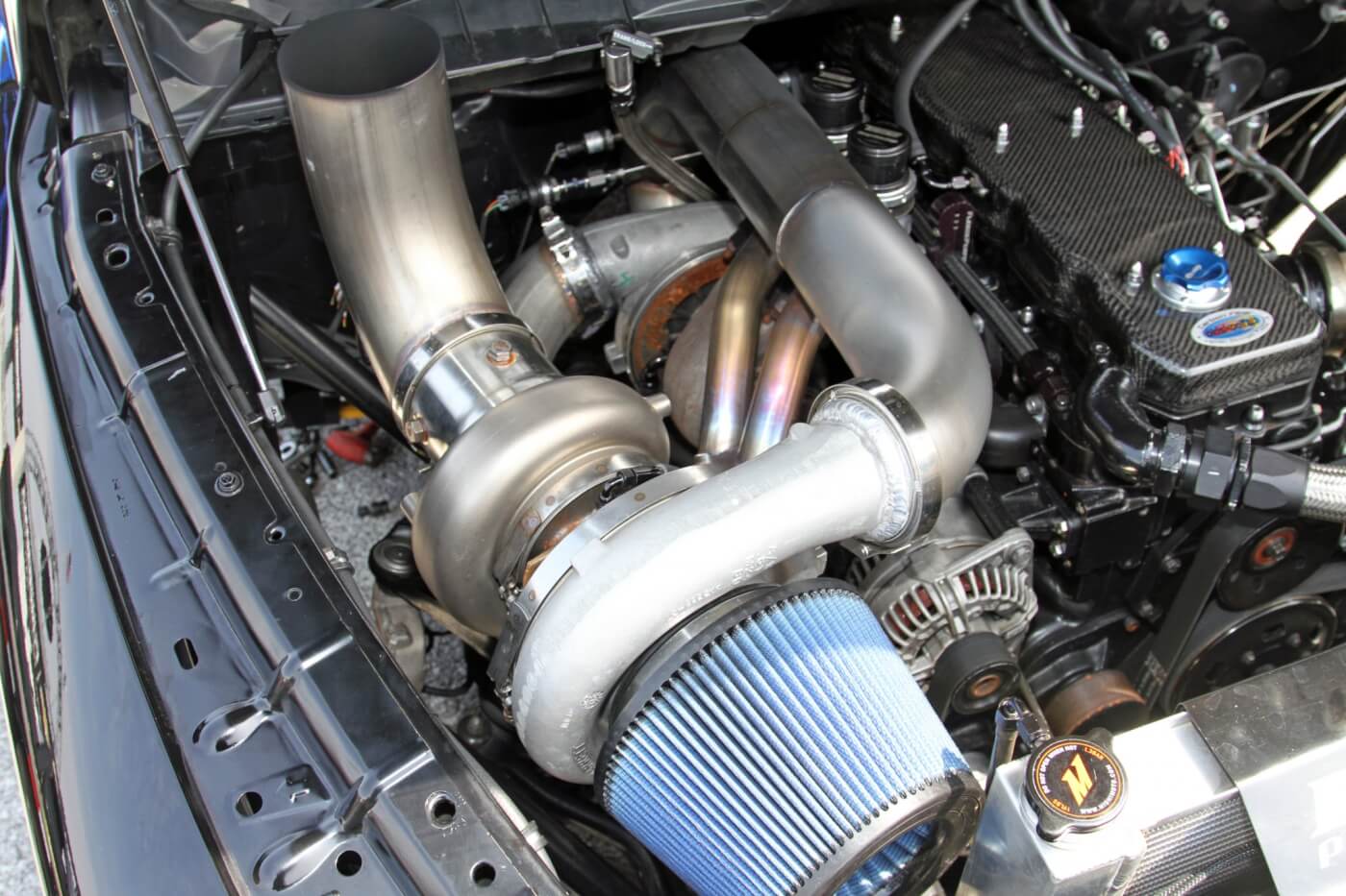 A large Garrett turbo is the primary, while a large Fleece Performance Engineering turbo is tucked under the Steed Speed manifold and custom stainless steel piping.