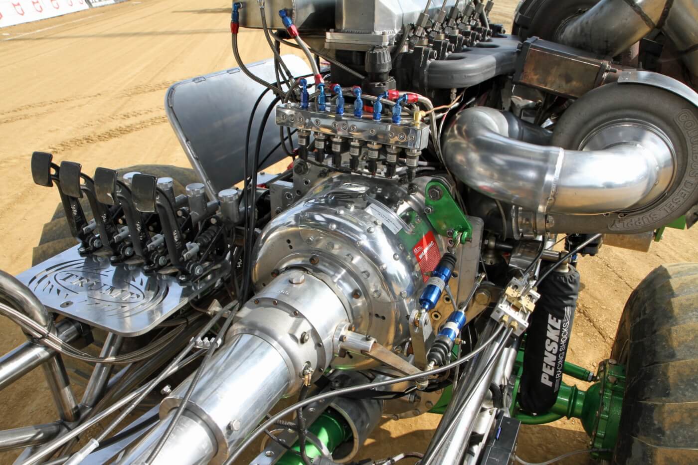 Power from the Cummins engine is channeled through an MRP 4-disc clutch housed within ProBell bellhousing. To make it possible to back the truck up to the sled, Kellogg relies on an SCS Gearbox reverser connected directly to the bell housing. You can also see the array of pedals he uses for the truck to control left and right independent front braking as well as the clutch and reverser.