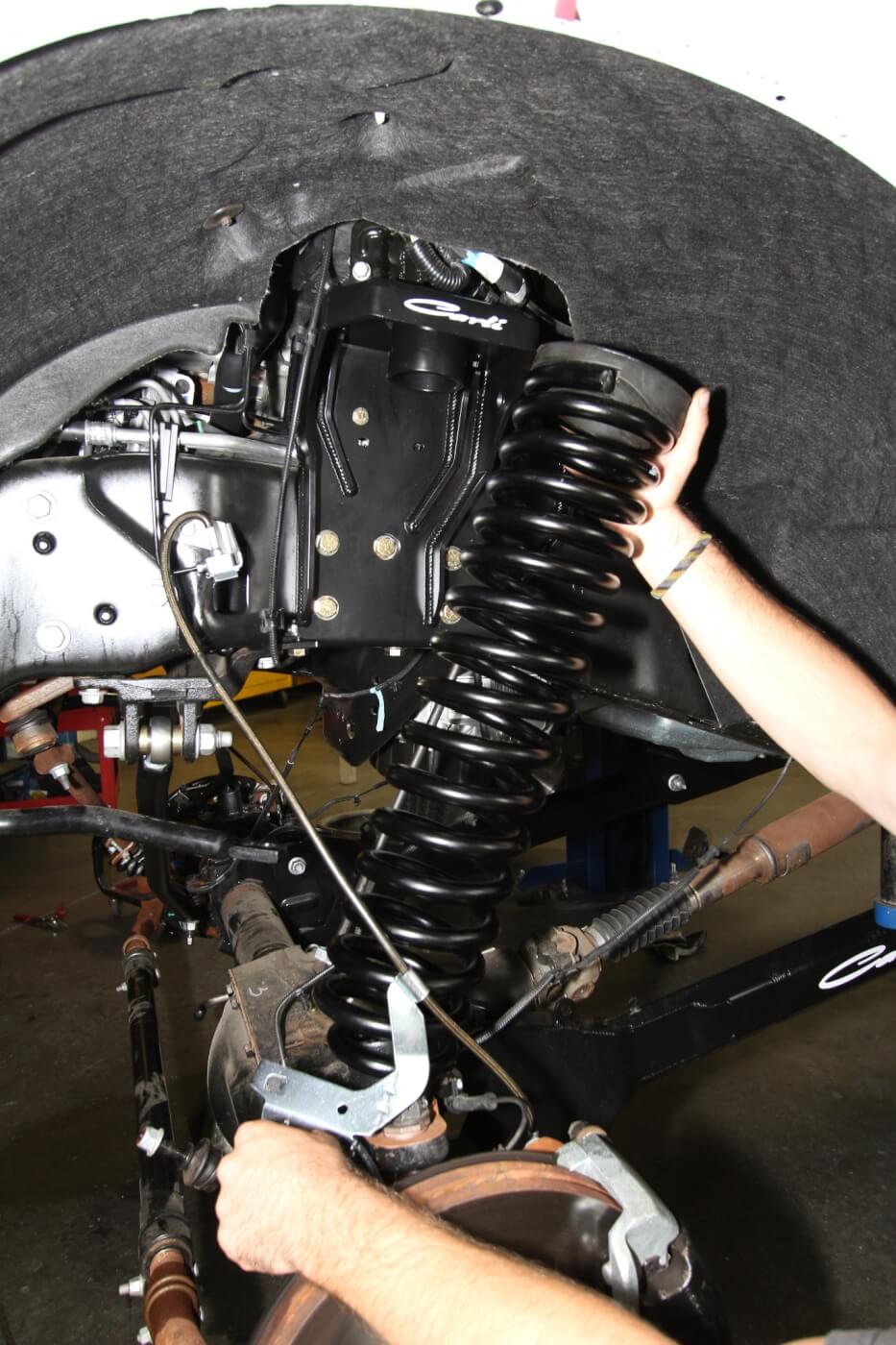 6. Longer, braided stainless steel brake lines are installed and then the new, longer front coils are put in place. 