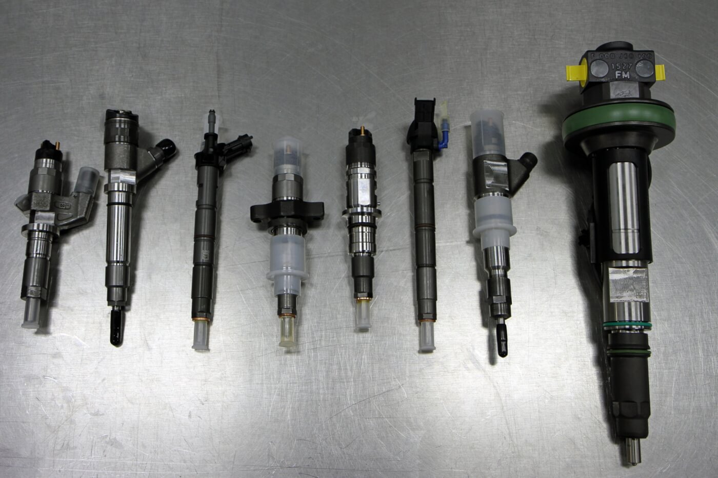 14. Here is a selection of some of the injector options offered by S&S Diesel Motorsport covering everything from stock type injectors up to monster injectors for custom applications. From left to right are injectors for an LB7, LBZ, LML (piezoelectric), 5.9L Cummins, 6.7L Cummins (next gen), 6.7L Scorpion, Case IH and LE (Large Engine with 2.5 to 3.0L per cylinder).