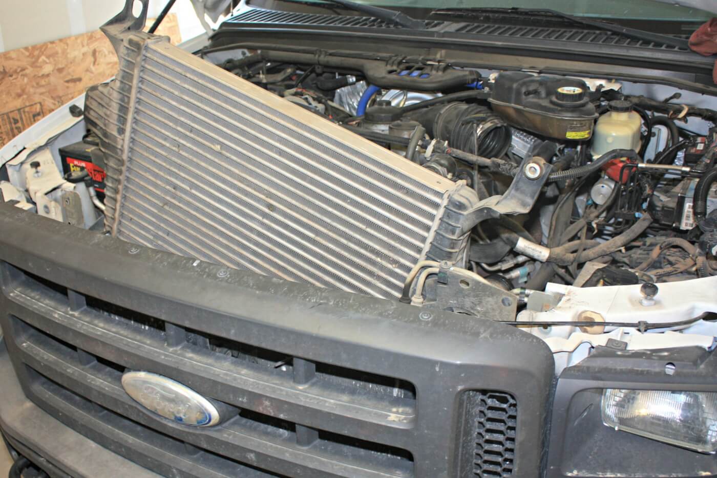 11. Once the upper core support and factory intercooler pipes have been removed, it’s just a matter of wiggling the stock intercooler up and out of the truck. It may be worth your while to enlist the help of a friend for this part of the job, as the intercooler can be a bit tough to sneak out by yourself.