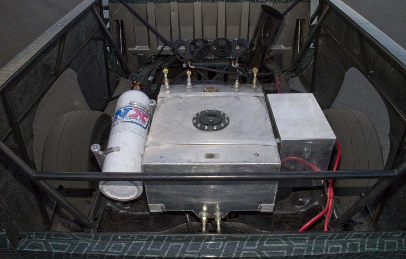 Between the frame rails, in the back of what was the bed space, you’ll find a 15-gallon fuel cell, nitrous tank, transmission cooler with fan and the battery box. This weight is strategically placed over the rear axle to improve traction. 
