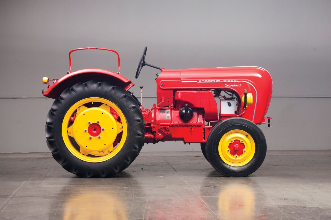The Porsche-Diesel Standard isn’t a big tractor but was designed to be versatile. It was an adjustable tread tractor, with a wheel track spacing adjustable from 49 to 73 inches. If the front wheels look familiar, think Volkswagen. The tractor used a five speed manual from ZF and had reduction gears in a portal style final drive. One of the unique features in the Porsche-Diesel tractor was a hydraulic coupling. It operated much like a torque converter, and you only needed the foot clutch for gear changes. The hydraulic coupling provided a load-sensing device that worked as an automatic torque amplifier. Wheel weights were available, but we don’t have specs on what was the maximum amount for the Standard. They also used liquid in the tires.