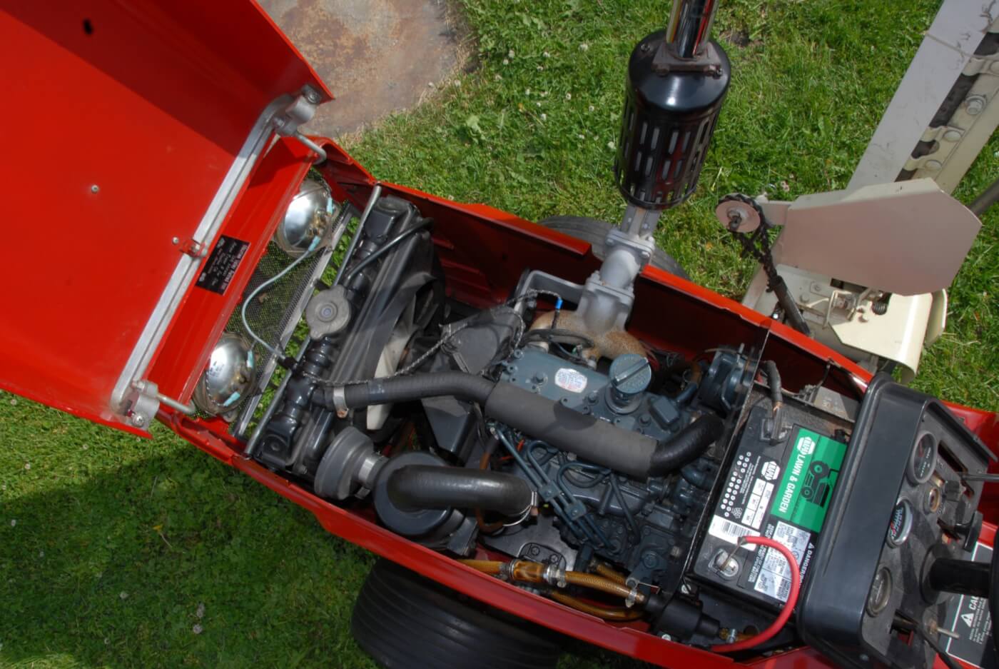 It’s small, but it's a real diesel! The water cooled Kubota D-600B is a tiny three-cylinder natural-aspirated indirect-injected engine that can make up to 15 intermittent horsepower at 3,600 rpm. It displaces almost 37 cubic inches and uses a Bosch MD mini-pump with Bosch throttle type injectors that open at 1,991 psi. The pump is fed at 7 psi from a 4-gallon tank via an electric pump. The crankshaft is supported by four main bearings and the cylinders are dry sleeved in the iron block. The engine assembly, including the radiator and fan, weighs 136 lbs. The only downside to the installation is that the lawn and garden-sized battery may not always be up to spinning the 23:1 CR diesel in cold weather; a block heater was optional and probably necessary when using the 782D for winter work.
