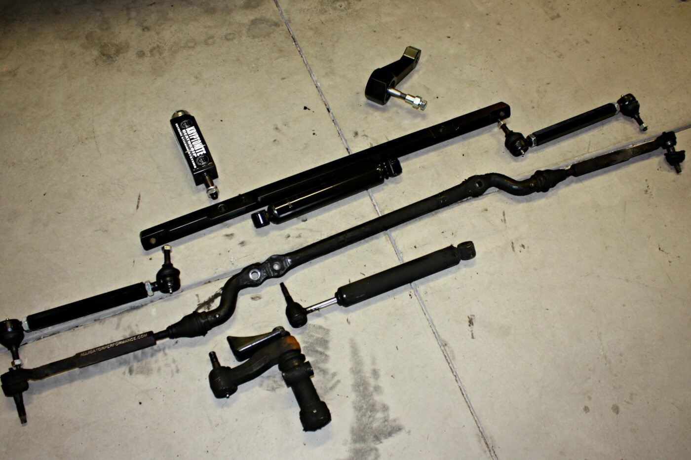 11. The entire factory steering assembly (bottom) was removed from the truck and laid out next to the new Ultimate Steering Package (top) from Dmax Store. The center link is sturdy and the tie rods are designed to stand up to abuse.