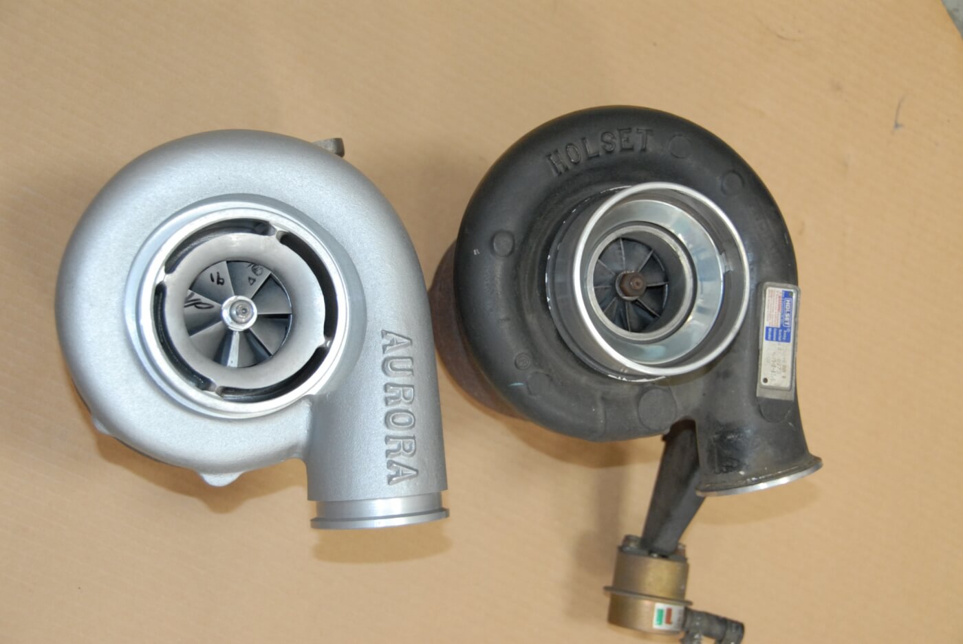 2. This close-up shows the differences between the Aurora 2000 turbo, next to the stock Holset unit. Besides the lack of a wastegate, note the larger discharge outlet on the Aurora, and slightly different exit angle, which allows air to exit more quickly from the compressor wheel. In addition, there’s an inducer or bleed ring (the gap at the perimeter) to enhance the width of the boost map. And the compressor vanes have extended tips and a steeper pitch.