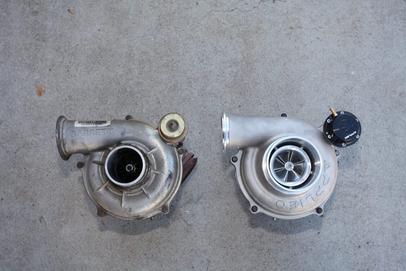 2A/2B. Here you see a comparison between the stock turbo (L) and the new Applied Performance Products turbo (R). The new turbo is almost the same size on the exterior for an easy fit, but the internals are built to move more air. Notice the new Applied Performance wastegate actuator. This billet aluminum heavy-duty adjustable wastegate actuator is pre-set at 24 psig. The wastegate actuator has a quick-adjust design, which eliminates the need to disconnect the actuator from the wastegate valve. It’s available separately and can be used on stock turbos. 