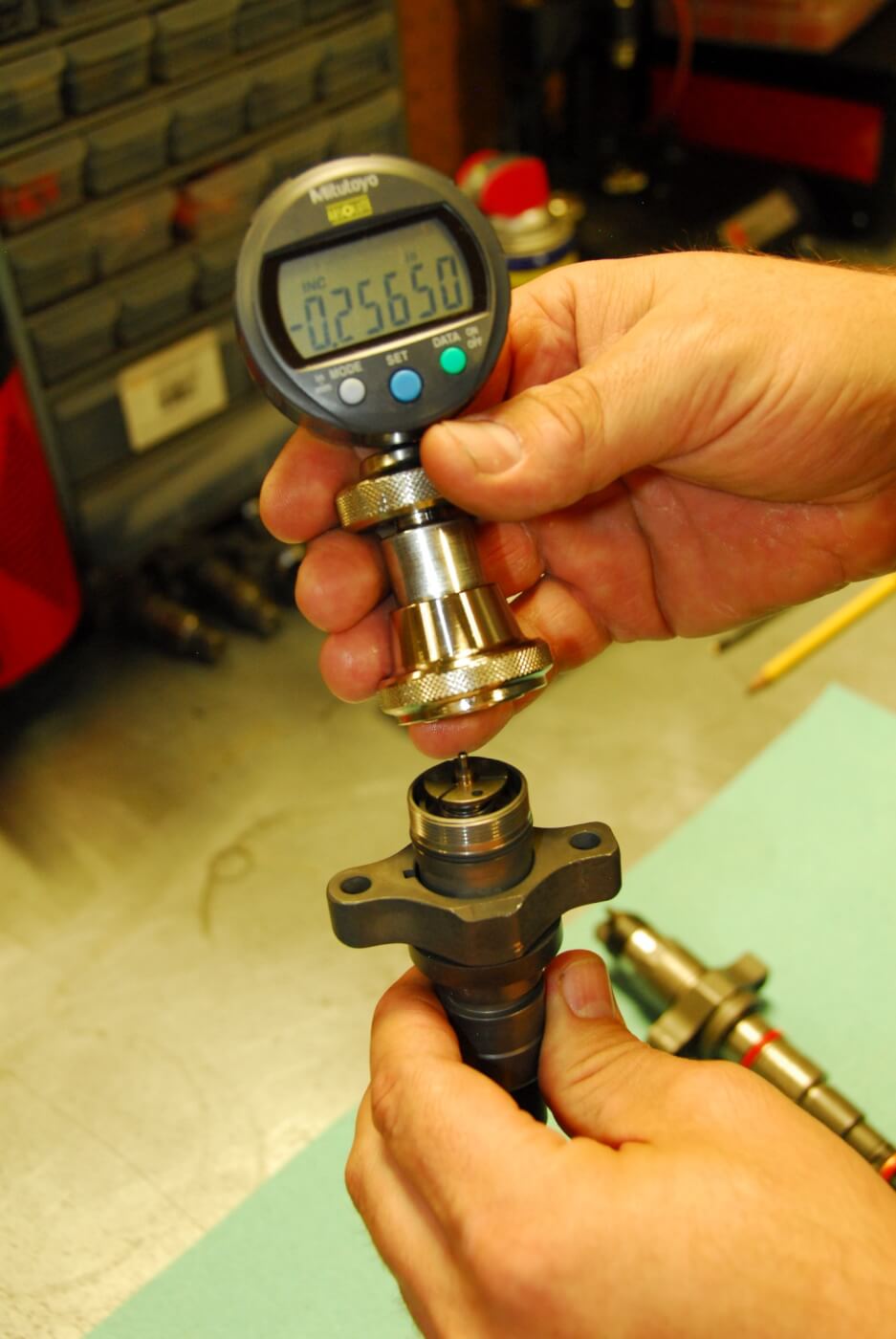 11. This gauge is fitted on the intermediate assembly of an injector to measure the air gap between the solenoid and armature, which can be adjusted with a shim.