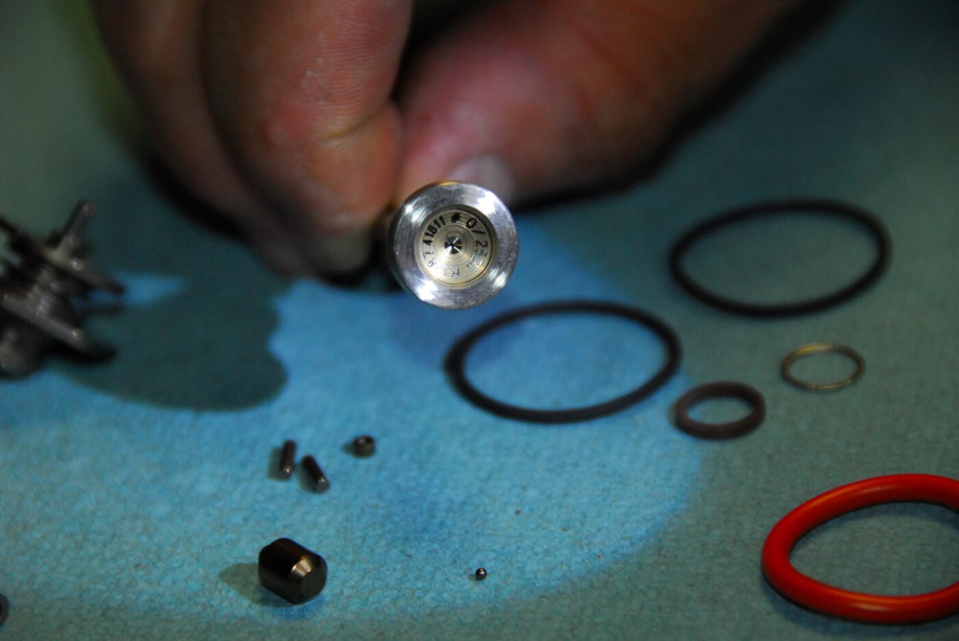 6. Here’s a close-up of the ball seat of the valve set. Look closely, and you’ll see a small ball on the table, directly below. This 1mm pellet is a critical component in the functioning of the injector. If the seat for the ball is even slightly damaged (usually by moisture or debris) the injector won’t function properly.