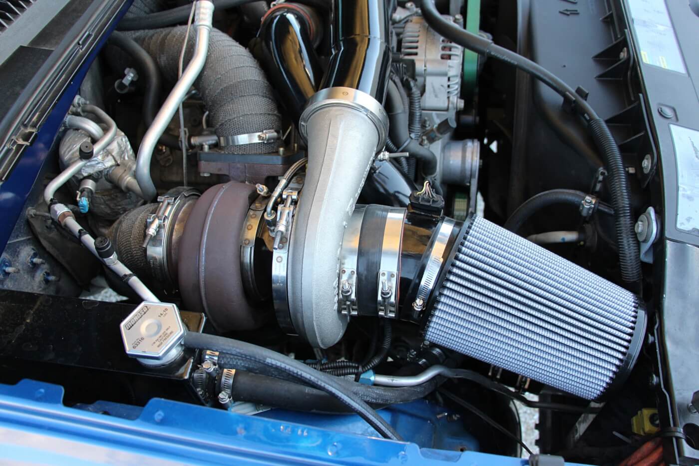 Kicking the passenger side battery out of its original location is this billet S480. It features the common 96mm turbine wheel, T6 flange, and 1.32 A/R turbine housing combination. In conjunction with the billet S366, the compound setup produces between 70-75 psi of boost on the street.