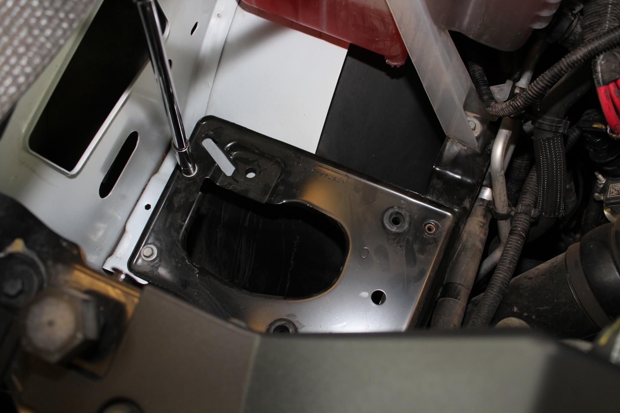 4. Beneath the stock intake box is a flat metal panel that also needs to be removed to make room for the larger AIRAID box. It’s held in place with four 10mm bolts. The plate can be discarded but save the bolts for re-use.