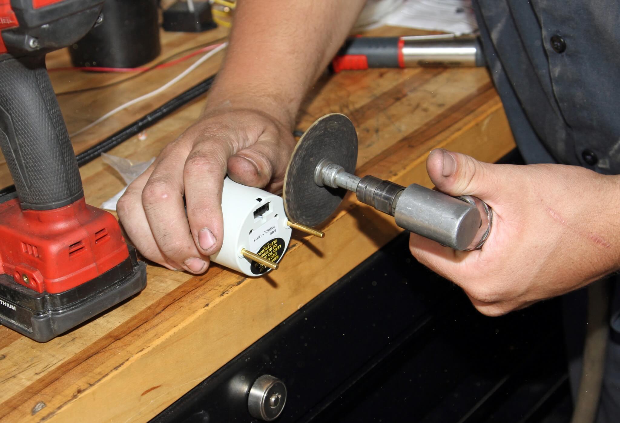 6. Carter cuts off the mounting studs from the backside of the gauge to fit the HPOP gauge in the steering column pod.
