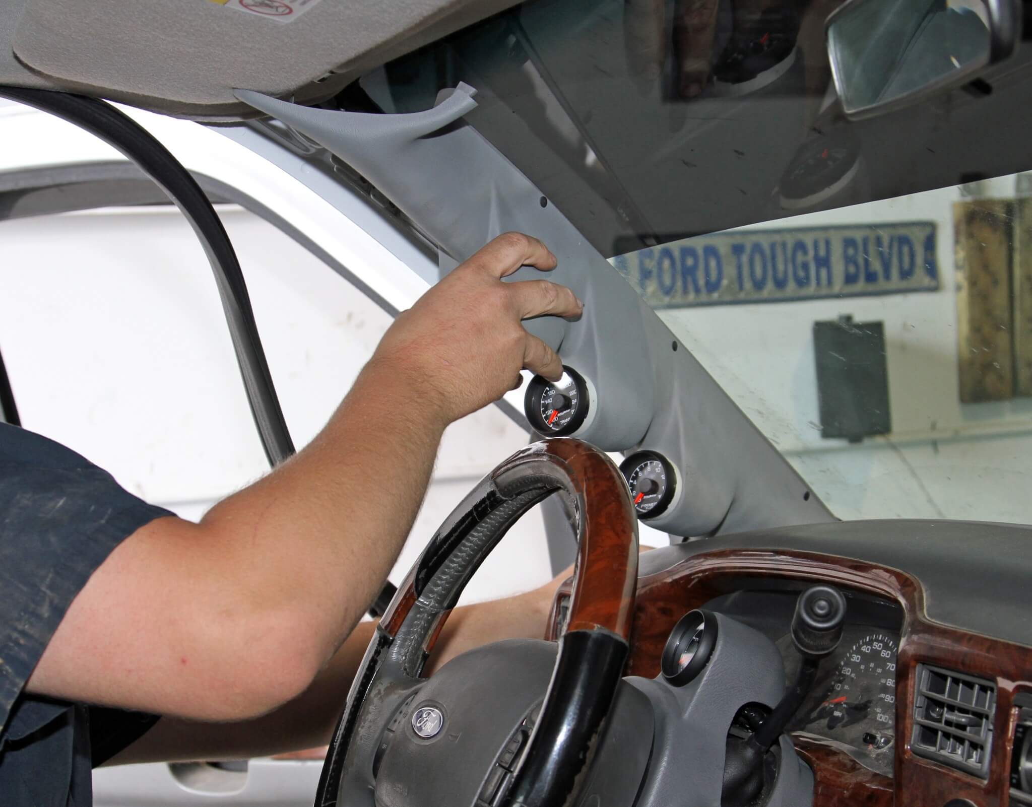 26. He then routes the harnesses through the A-pillar joint near the dash and installs the pod. He adjusts the angle of the gauges and presses them fully into the pod once it’s installed to verify the angle from the driver’s seat.