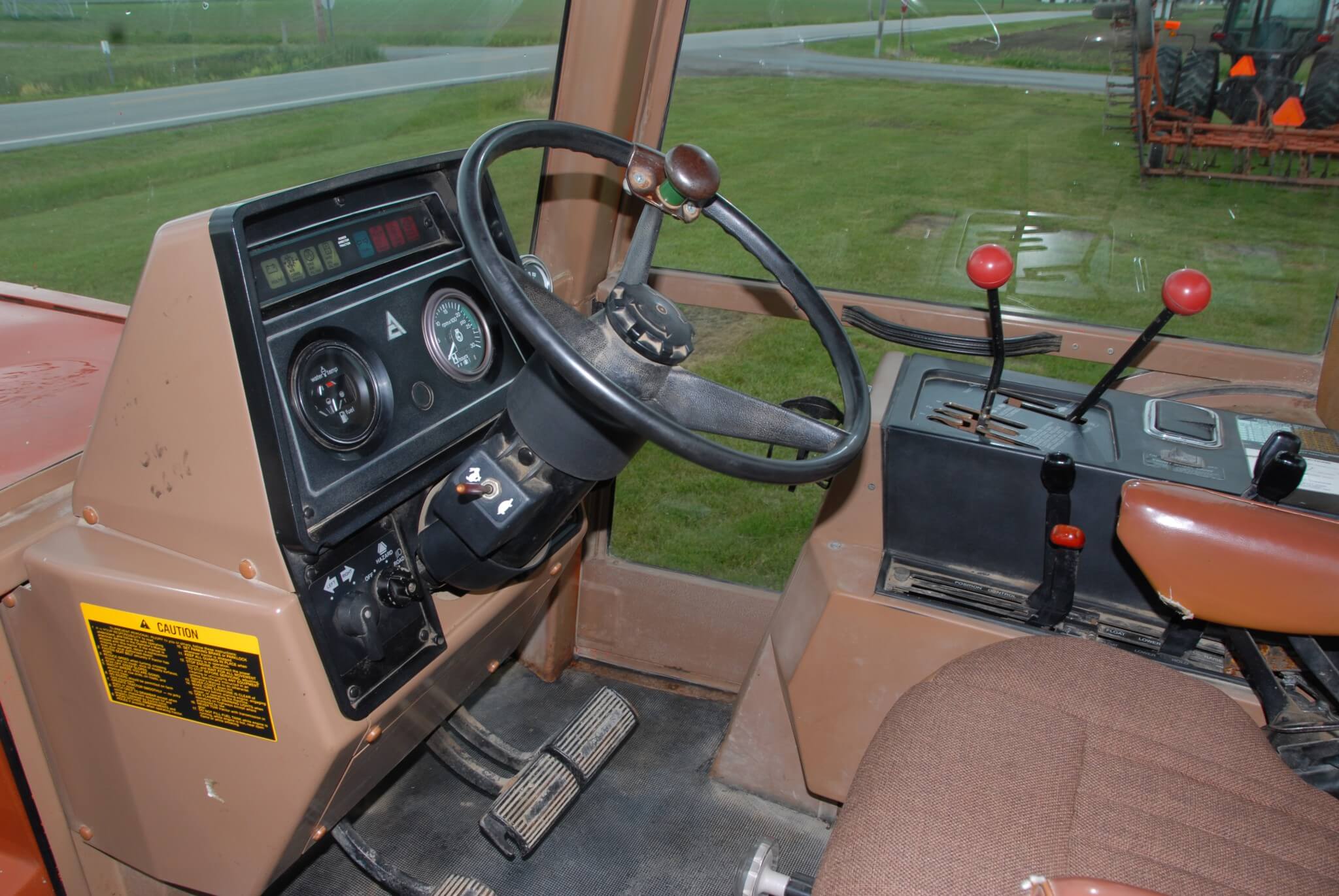 The cab was the equal of anything in the era and nicely laid out. This tractor has the 10-speed partial power shift trans, with a five-speed main gearbox and two-speed range box on the console to the right (tall levers). The partial power shift was controlled by the switch at the base of the steering wheel (rabbit and tortoise) which delivered a clutchless high and low in each of the manual gears.