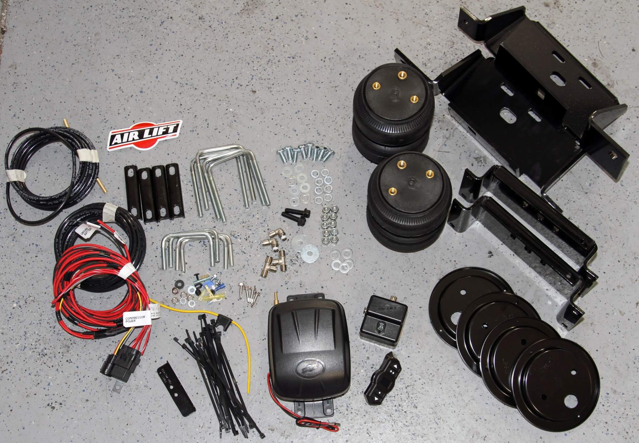1. Here you see the combined the Air Lift LoadLifter 5000 Ultimate air spring kit and WirelessOne compressor system. This package comes with everything needed to add remote load leveling capability to your truck in less than a day.