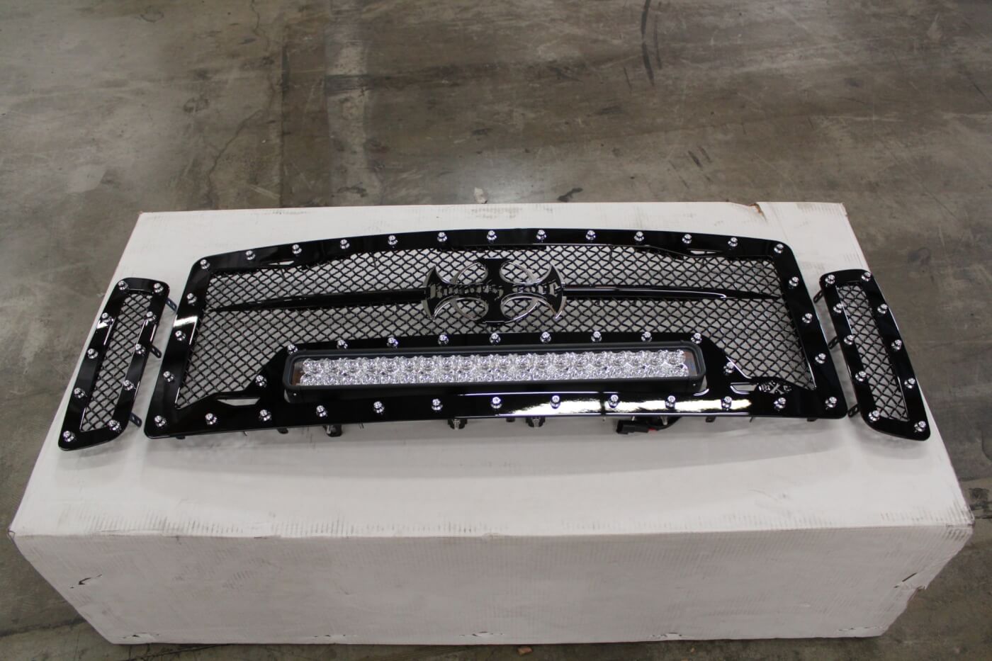 1. We decided to take a two-pronged approach to our truck's new nose. The first was the TrailReady bumper, installation of which was covered in our last issue (Diesel World, December 2014). The second is a Royalty Core RC1X Incredible LED grille. This three-piece insert includes a gloss black mesh grille surround with nickel-plated stud accents around all three pieces. The center portion includes a 22-in. Vision X LED light bar on adjustable mounts with an included wiring kit. The grille feels solid and well constructed, with TIG welding and stainless steel mounting hardware.