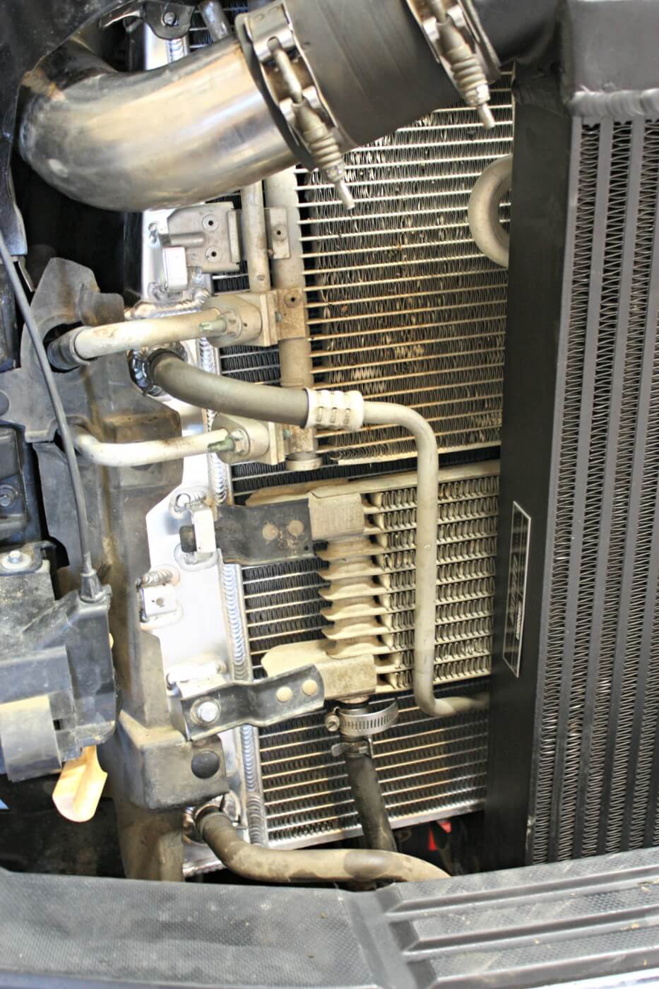 17. The new radiator comes equipped with mounting tabs and bolt holes that match the factory unit. Mishimoto supplies some new installation hardware, including the pieces needed to attach the A/C condenser. 