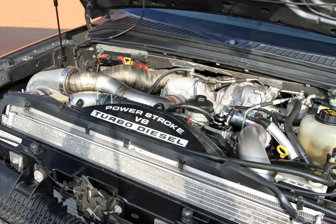 Lifting the hood on this F-250 reveals that the factory compound turbo setup has been supplemented with a large BorgWarner turbo.