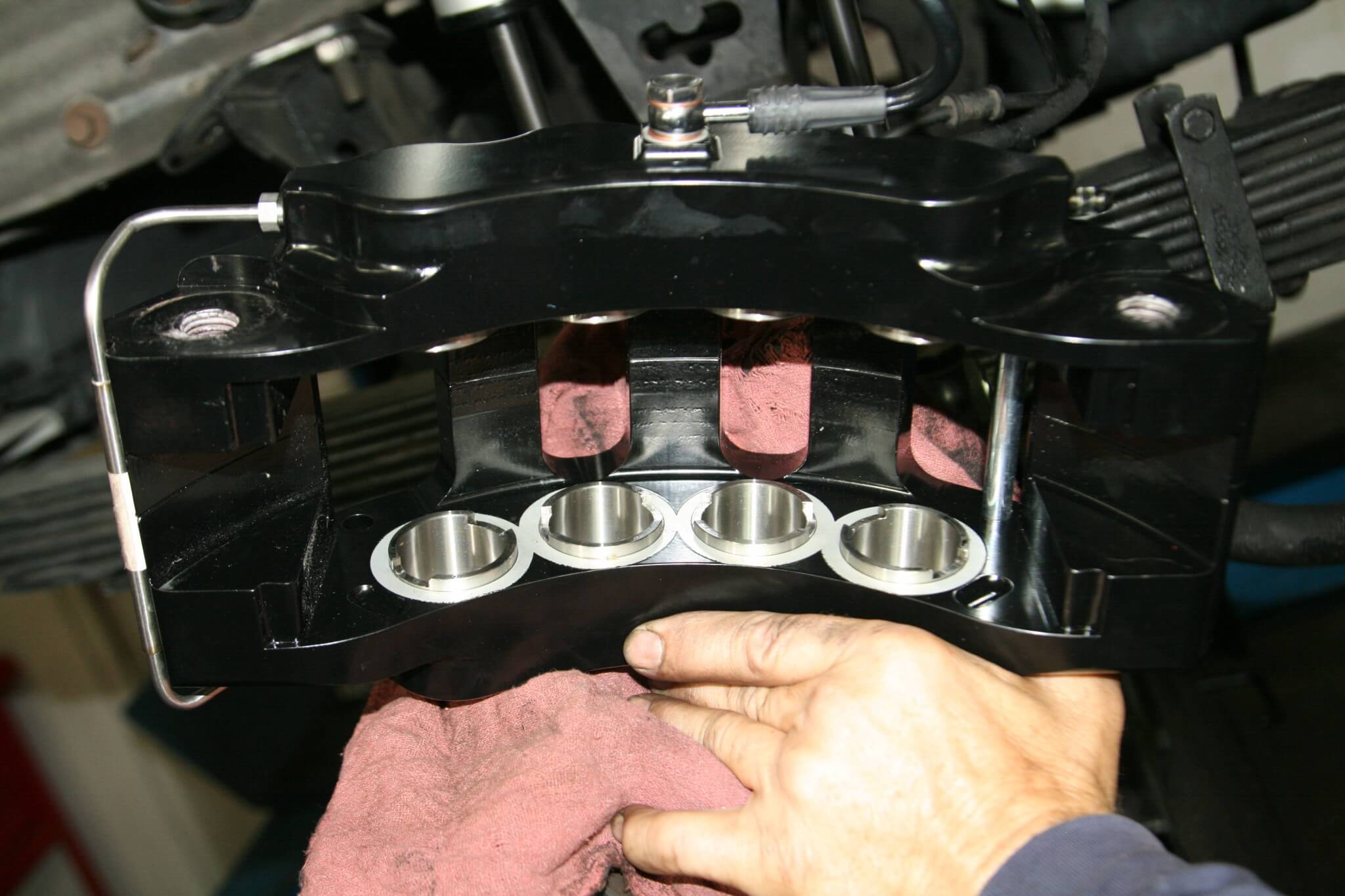 5. Here you can see the four pistons on one side of the SSBC V8 brake caliper. The V8 name is due to the fact that his piston has eight pistons, four on each side. The fixed caliper provides more braking pressure, a more even pressure distribution, and it uses less pedal travel to do it. 
